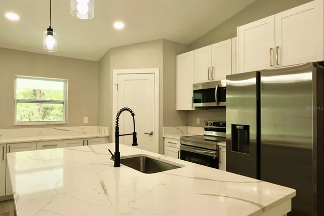 a kitchen with a refrigerator and a sink