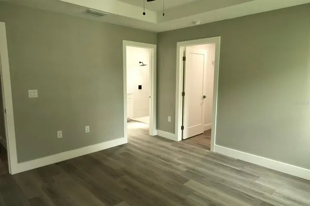 an empty room with wooden floor and closet