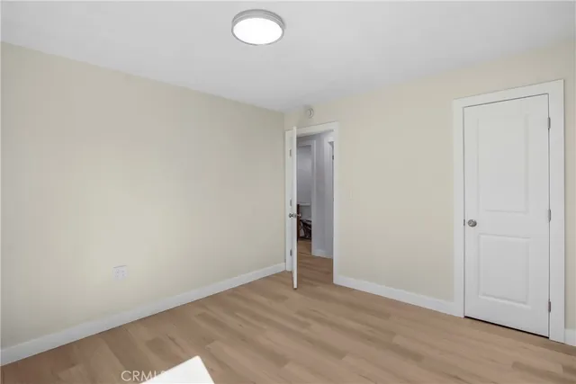 an empty room with wooden floor and closet