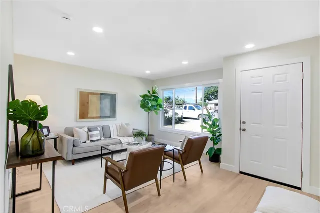 a living room with furniture a potted plant and a table