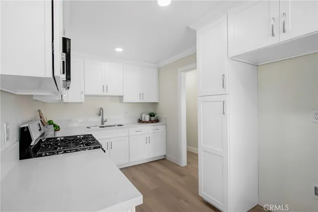 a kitchen with a sink a stove and cabinets
