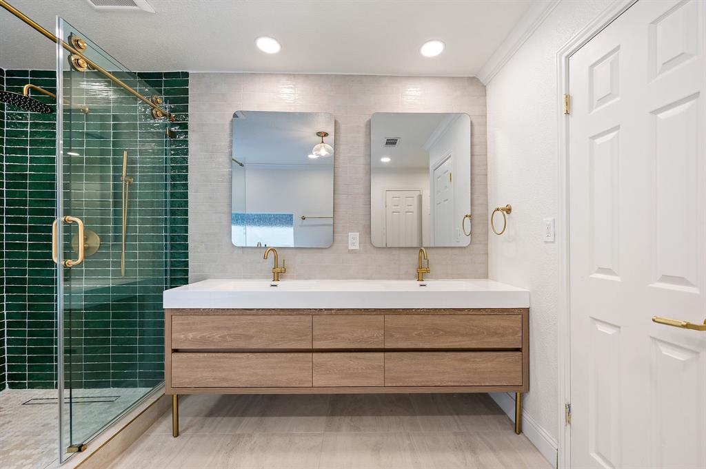 6403 Genstar Lane Dallas, TX 75252 - Photo 19 of 34 Dual vanity with wood-finish cabinetry, integrated sinks, and brass fixtures