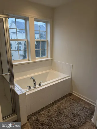 a bathroom with bathtub and window