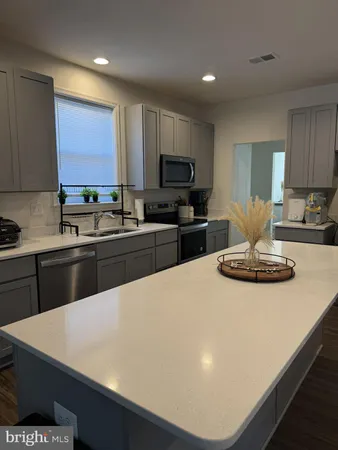 a kitchen with stainless steel appliances a stove a sink a microwave a refrigerator a counter top space and cabinets