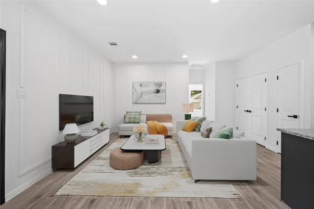 a living room with furniture and a wooden floor