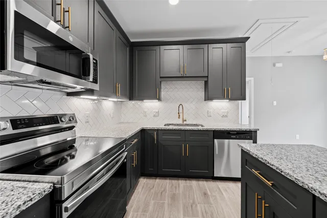a kitchen with kitchen island granite countertop a sink and steel appliances