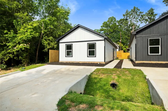 a view of a house with backyard and trees