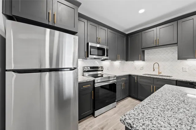 a kitchen with stainless steel appliances granite countertop a refrigerator sink and microwave