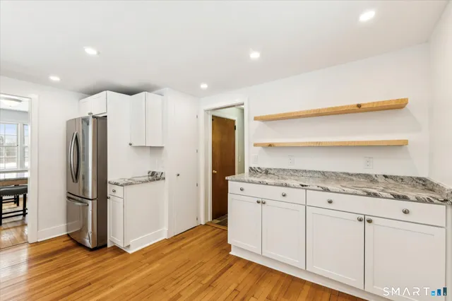 a kitchen with granite countertop a refrigerator and a stove top oven