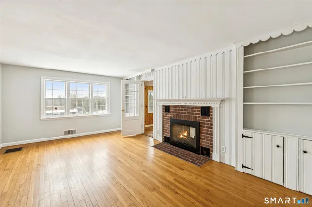 a view of an empty room with a fireplace and a window