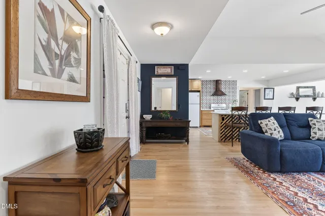 a living room with furniture kitchen view and a chandelier