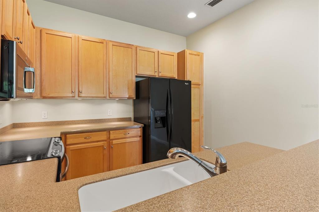13222 Huerta Street Venice, FL 34293 - Photo 13 of 85 a kitchen with a refrigerator and cabinets