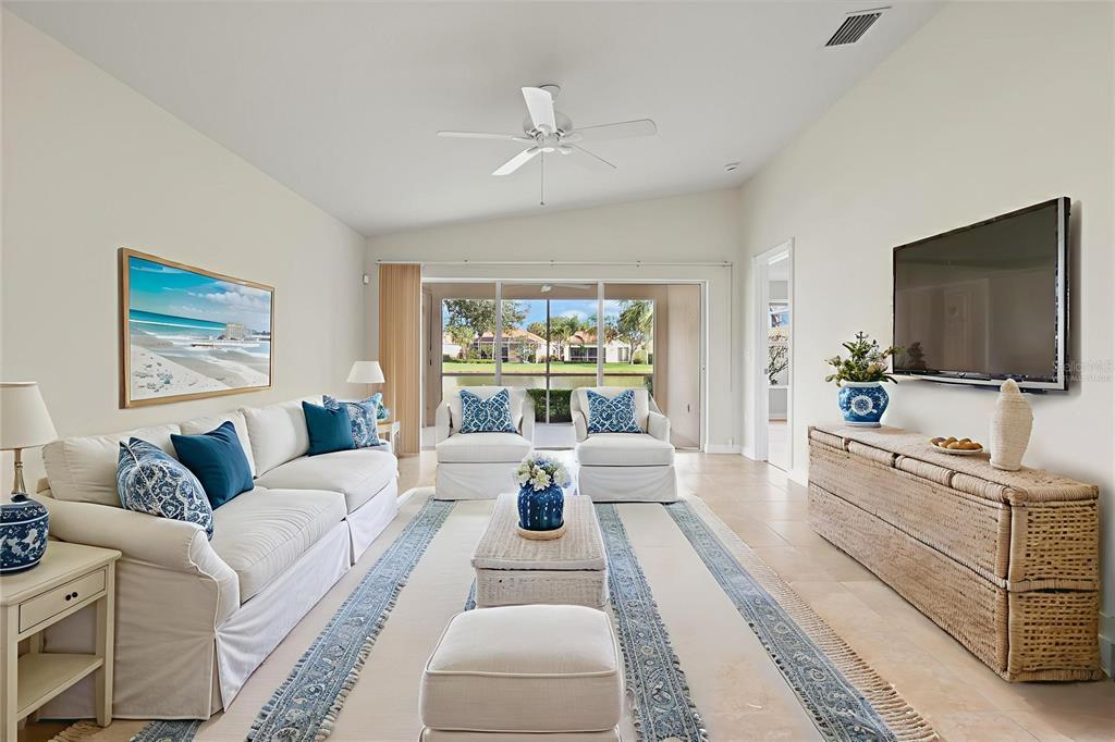 13222 Huerta Street Venice, FL 34293 - Photo 19 of 85 a living room with furniture a flat screen tv and a large window