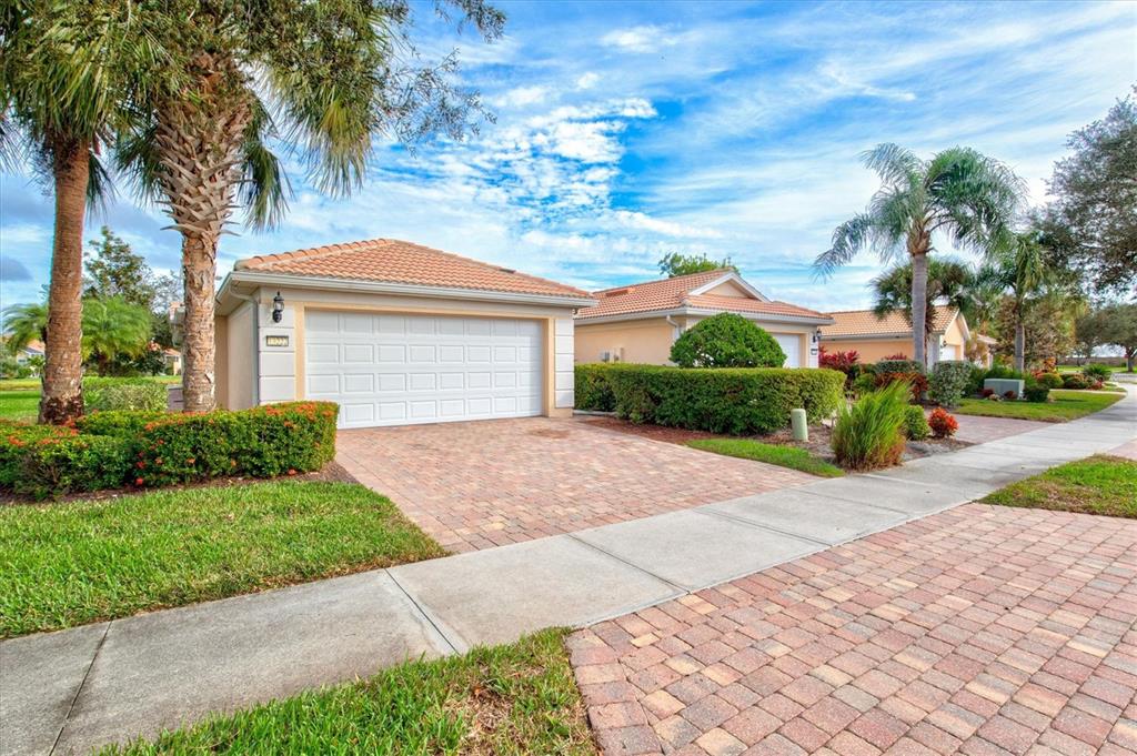 13222 Huerta Street Venice, FL 34293 - Photo 2 of 85 a front view of a house with a yard and potted plants