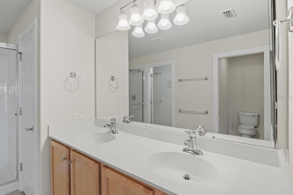 13222 Huerta Street Venice, FL 34293 - Photo 32 of 85 a bathroom with a sink double vanity and a mirror