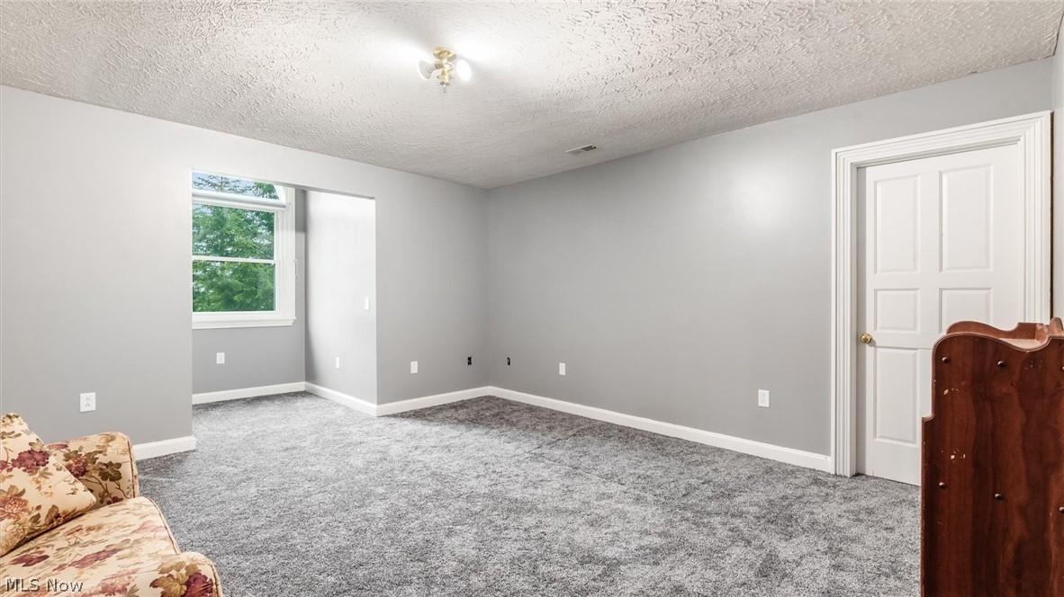 2531 Nicholas Lane Dresden, OH 43821 - Photo 24 of 40 Spacious room featuring light gray walls, gray carpeting, a window with white trim, white baseboards, and a white panel door
