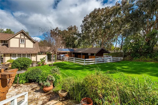 a front view of a house with a yard and potted plants