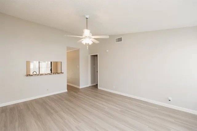 a view of an empty room with wooden floor