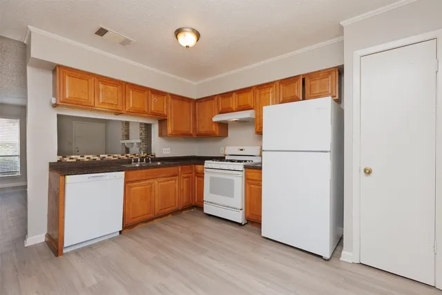 a kitchen with granite countertop appliances a sink and a refrigerator