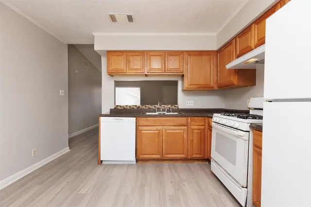 a kitchen with stainless steel appliances granite countertop a stove a sink and a refrigerator