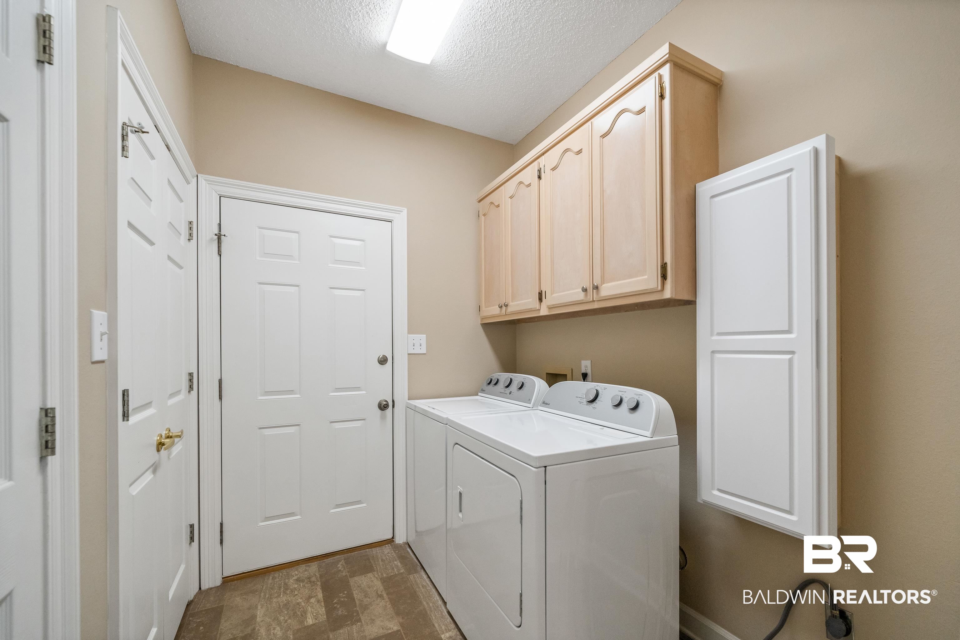 27 Cottage Drive Fairhope, AL 36532 - Photo 26 of 33 Washroom featuring cabinet space, a textured ceiling, and independent washer and dryer