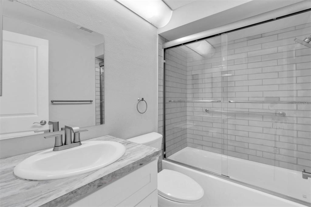 4343 Summersun Drive, Unit 4343 New Port Richey, FL 34652 - Photo 23 of 50 a bathroom with a granite countertop bathtub sink vanity mirror and toilet