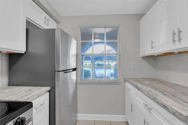 a kitchen with granite countertop a stove top oven microwave and cabinets