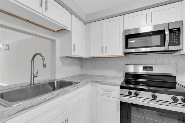 a kitchen with stainless steel appliances a stove a sink a refrigerator and cabinets