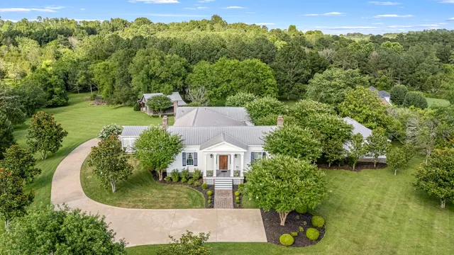 a front view of a house with a yard and trees