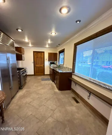 a large kitchen with stainless steel appliances granite countertop a sink and cabinets