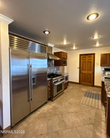 a kitchen with stainless steel appliances granite countertop a refrigerator and a stove