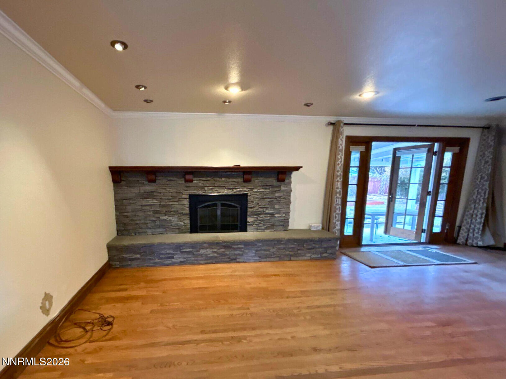 1010 Tyler Way Sparks, NV 89431 - Photo 8 of 11 an empty room with wooden floor and fireplace