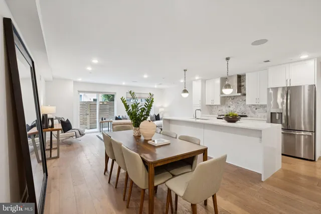a kitchen with a dining table chairs and refrigerator
