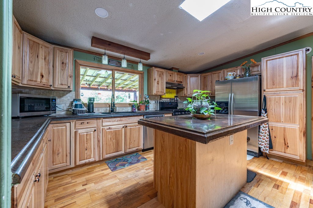 285 Roaring Fork Road Todd, NC 28684 - Photo 12 of 41 a kitchen with stainless steel appliances granite countertop a sink stove and refrigerator