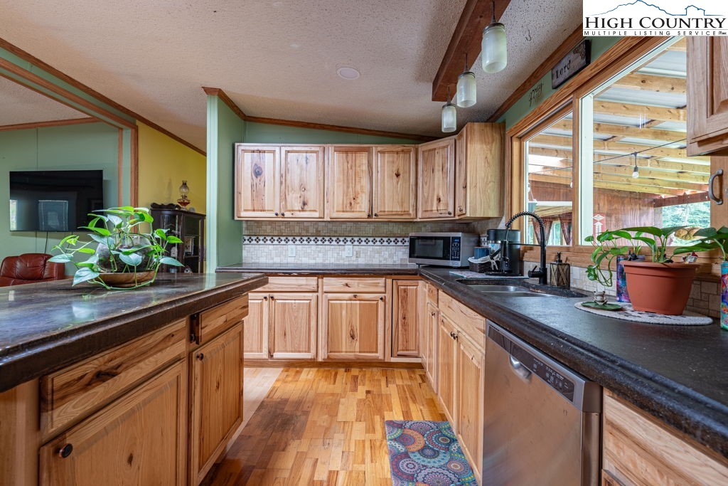 285 Roaring Fork Road Todd, NC 28684 - Photo 15 of 41 a kitchen with stainless steel appliances granite countertop sink stove and cabinets