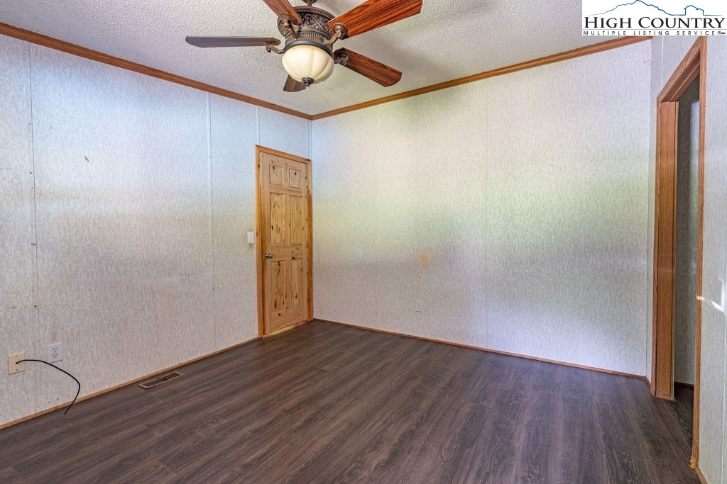 285 Roaring Fork Road Todd, NC 28684 - Photo 31 of 41 an empty room with wooden floor and fan