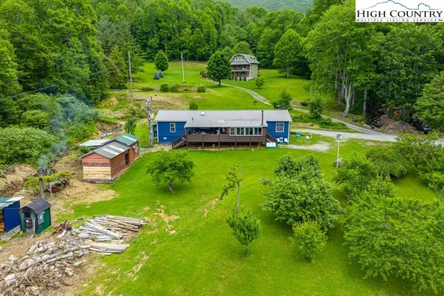 an aerial view of residential houses with outdoor space and trees all around