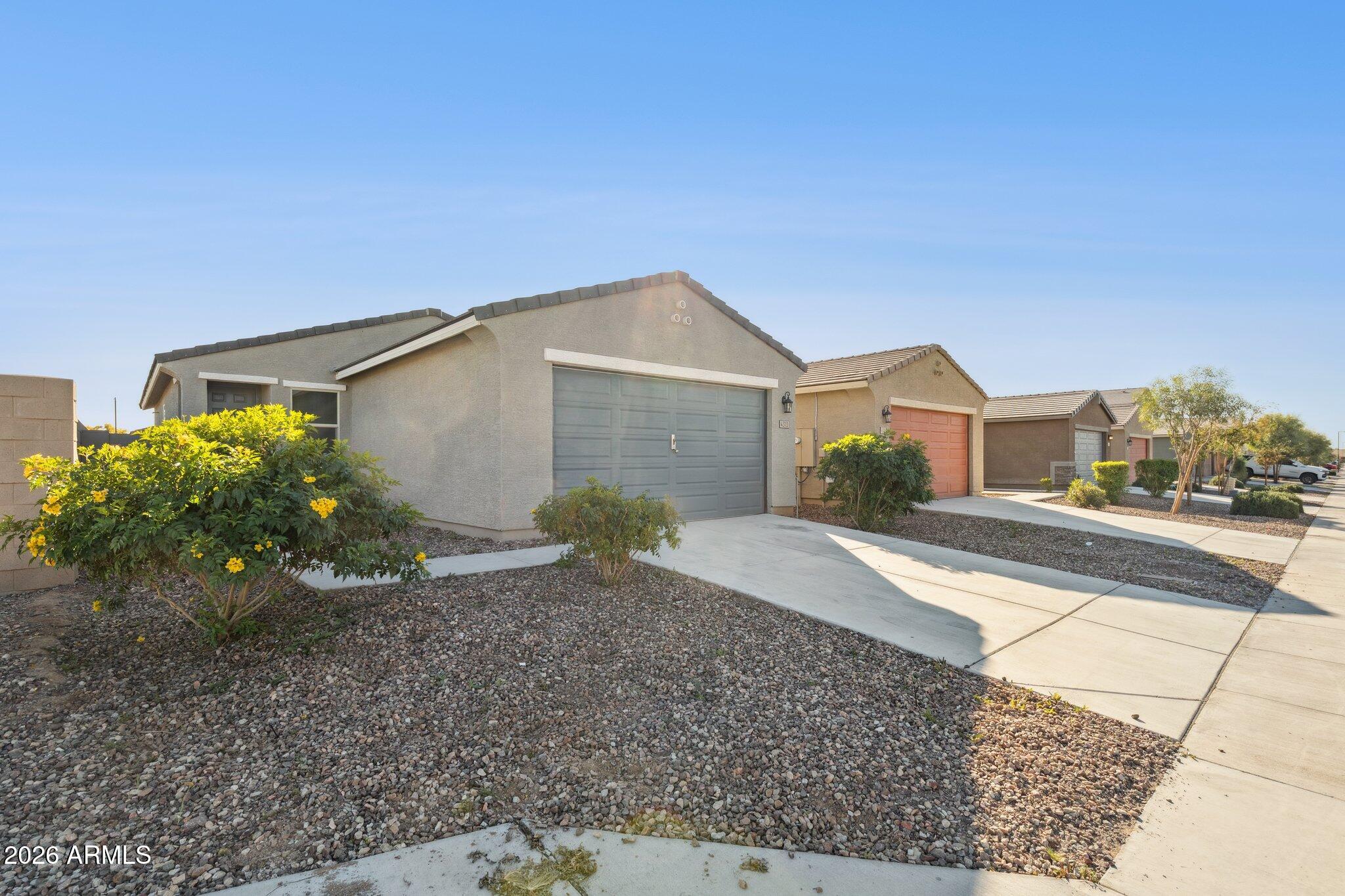 4313 West Allen Street Laveen, AZ 85339 - Photo 18 of 22 a front view of a house with a yard and garage