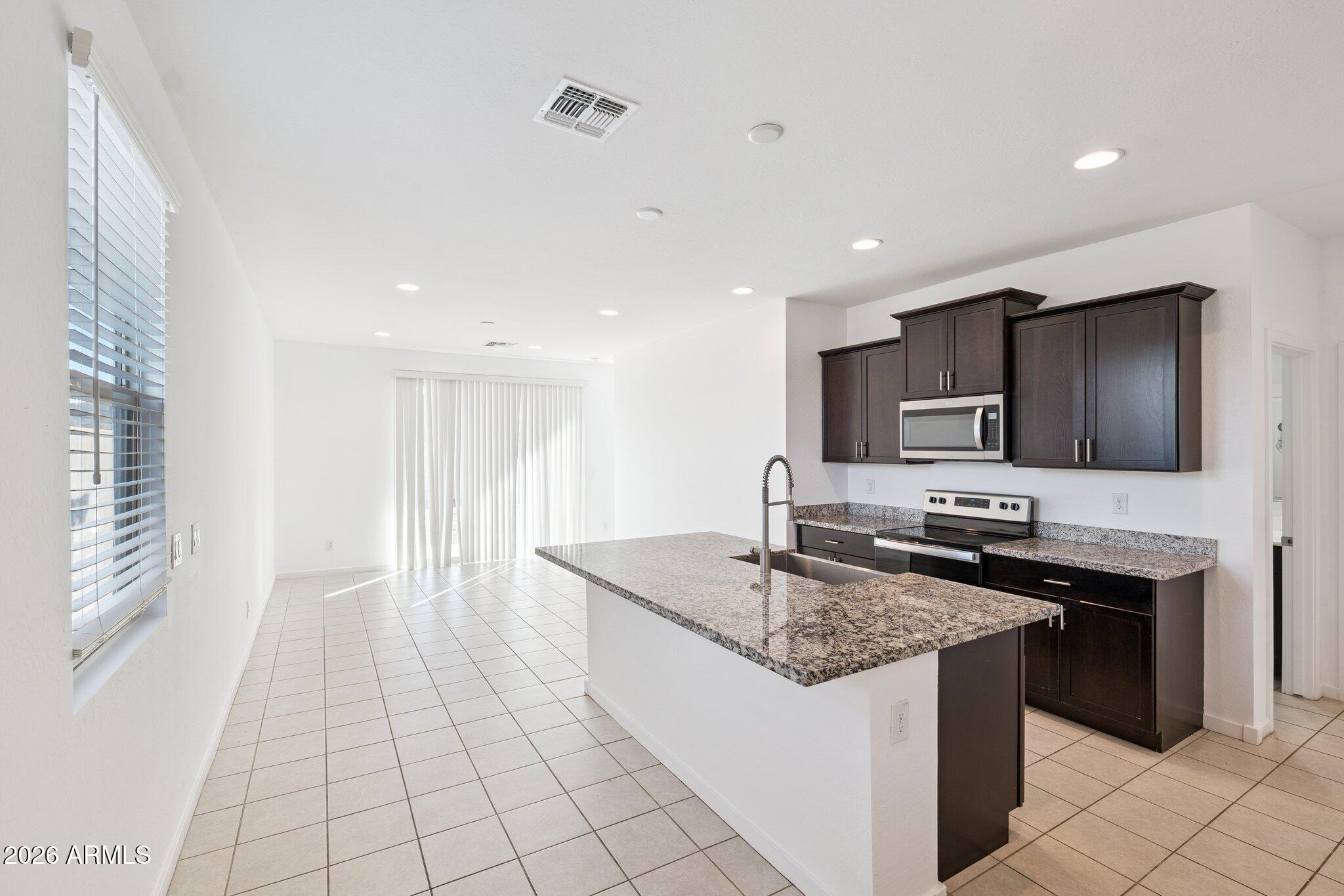4313 West Allen Street Laveen, AZ 85339 - Photo 3 of 22 a kitchen with stainless steel appliances granite countertop a sink stove and refrigerator