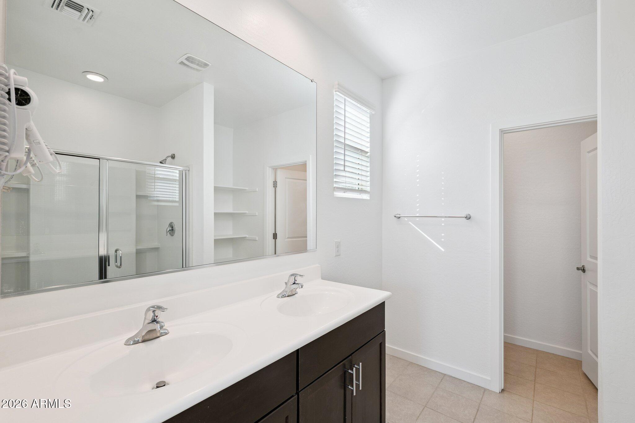 4313 West Allen Street Laveen, AZ 85339 - Photo 8 of 22 a bathroom with a sink a shower and a mirror