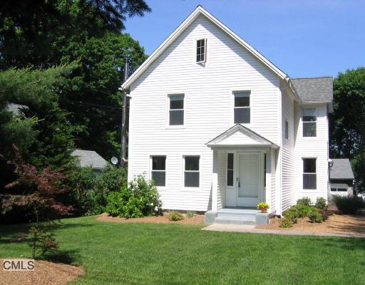 8 North Street Ridgefield, CT 06877 - Photo 1 of 1 a view of a white house next to a yard with plants and trees