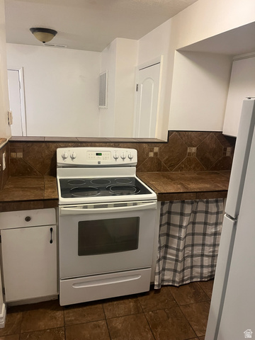 1175 Canyon Road, Unit A 5 Ogden, UT 84404 - Photo 11 of 15 Kitchen featuring a white electric range, dark tile flooring, and a coordinating dark tile backsplash