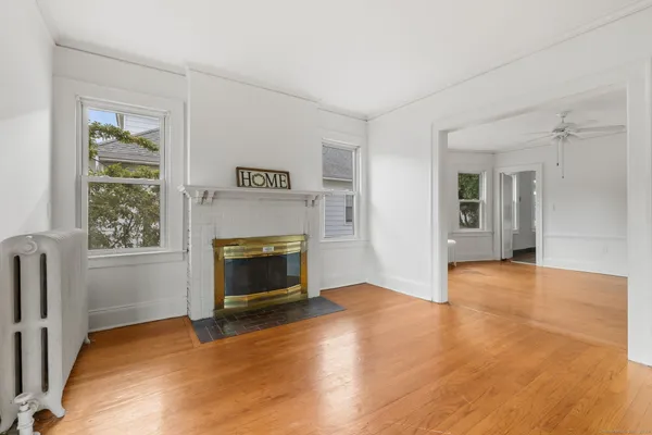 wooden floor fireplace and windows in an empty room