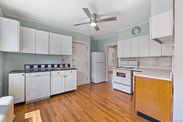 a kitchen with granite countertop white cabinets and white appliances