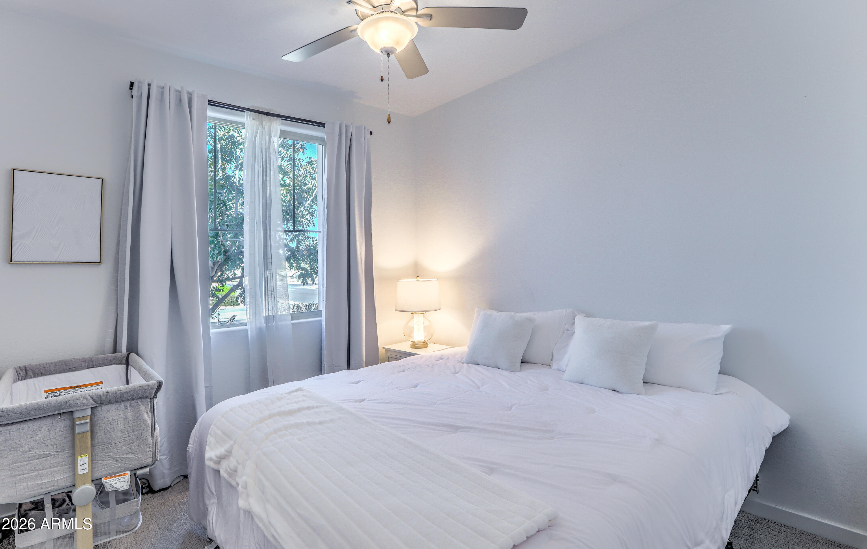 7727 West Agora Lane Phoenix, AZ 85043 - Photo 26 of 46 a bedroom with a large bed and a chandelier