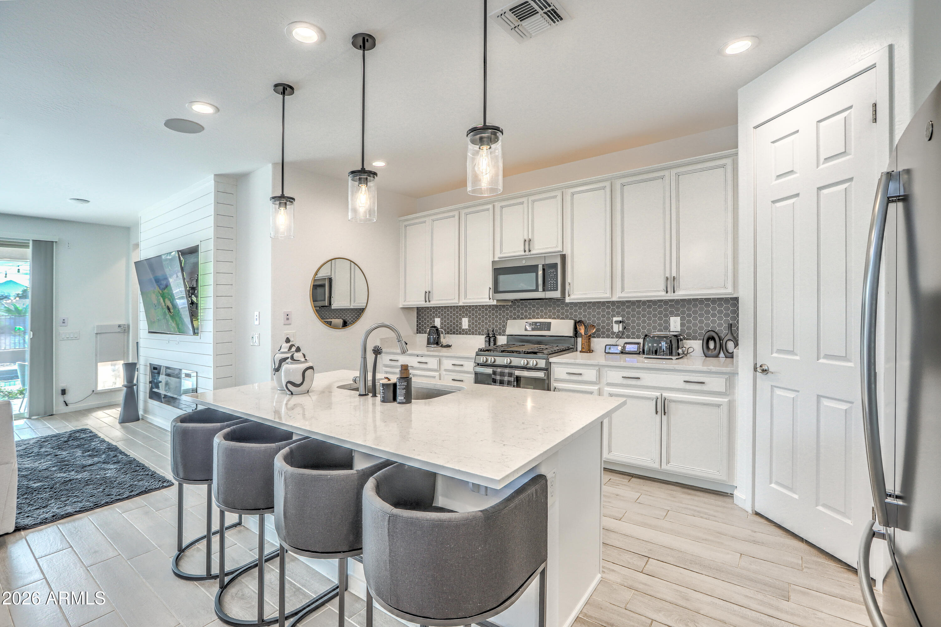 7727 West Agora Lane Phoenix, AZ 85043 - Photo 7 of 46 a kitchen with stainless steel appliances granite countertop a sink a stove a refrigerator and island with wooden floor