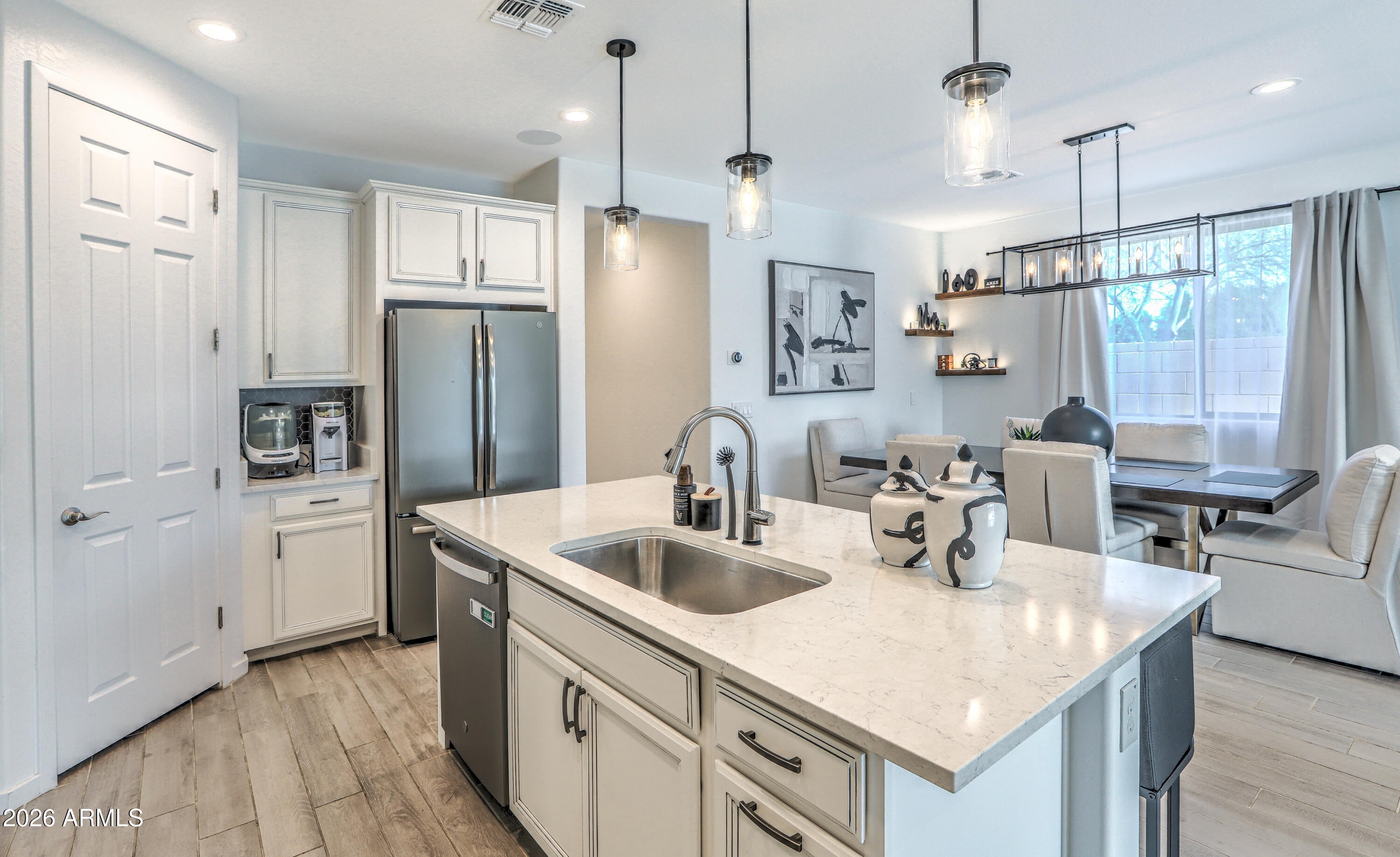 7727 West Agora Lane Phoenix, AZ 85043 - Photo 10 of 46 a kitchen with stainless steel appliances a sink a refrigerator a center island and couches