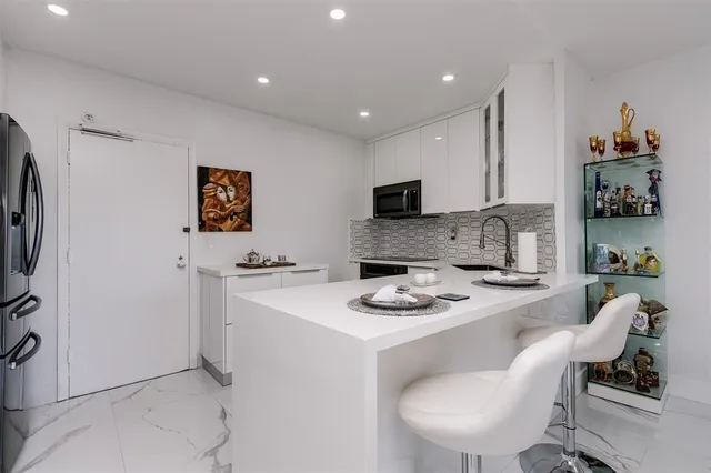 a white kitchen with a sink appliances and cabinets