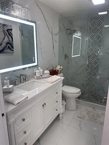 a bathroom with a granite countertop sink toilet and shower