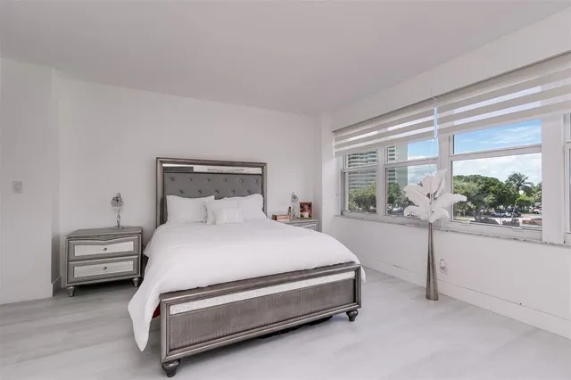 a spacious bedroom with a bed and a window